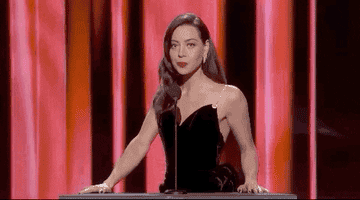 aubrey plaza wears a gown and stands at a podium, saying, &quot;scuse me?&quot;