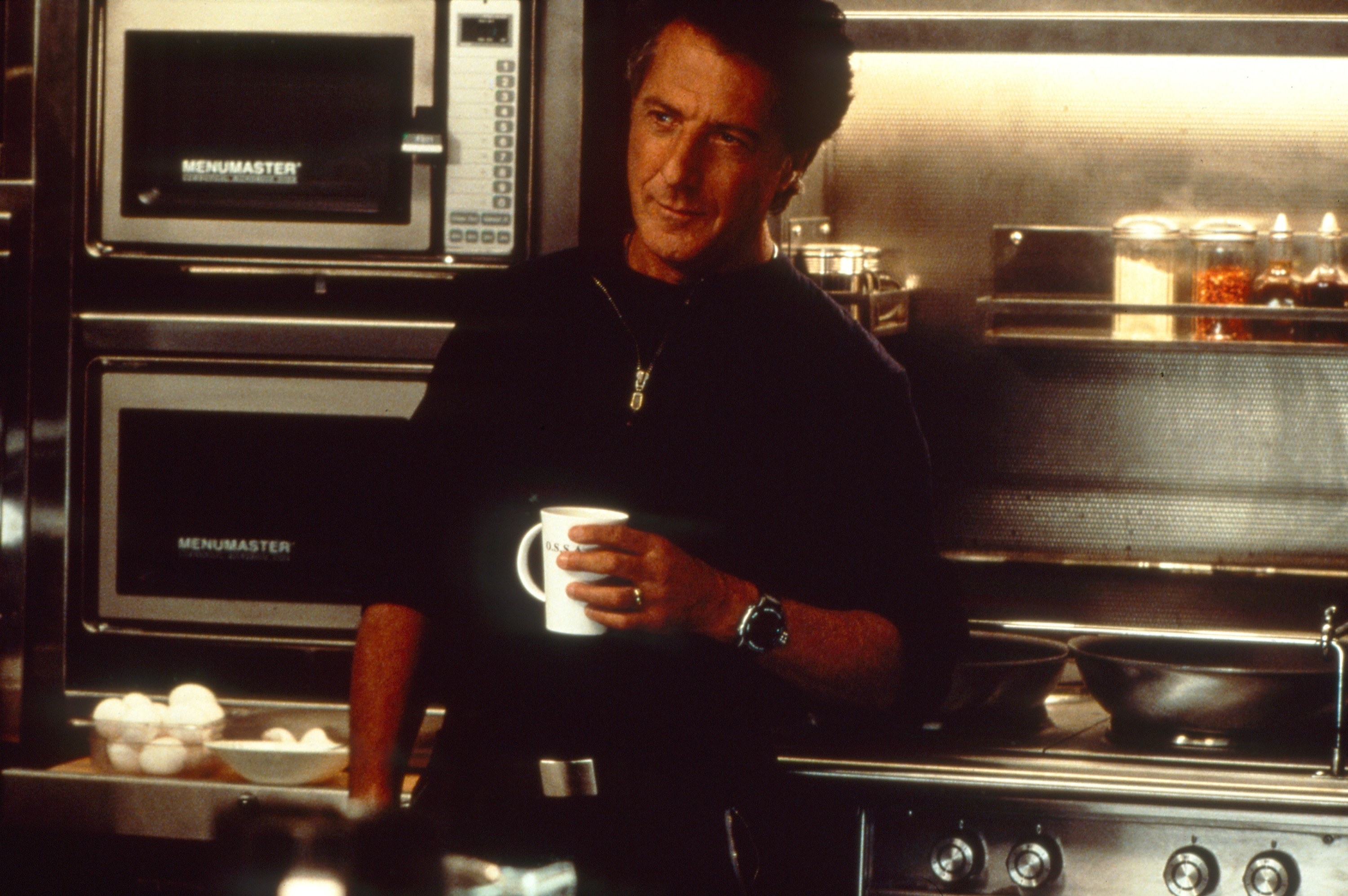 man in a kitchen holding a coffee mug