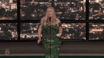 jennifer coolidge wears a gown and stands onstage, dancing