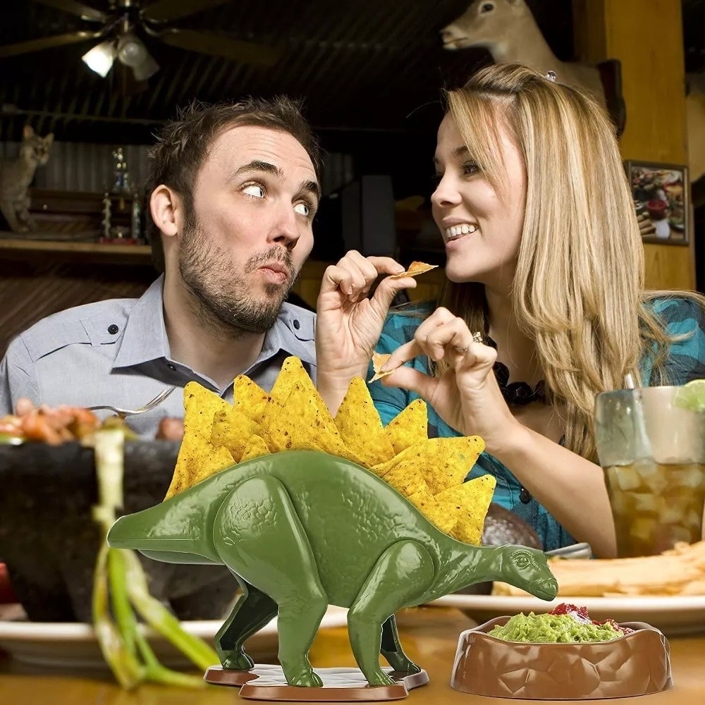 A couple eating chips with the dino snack holder