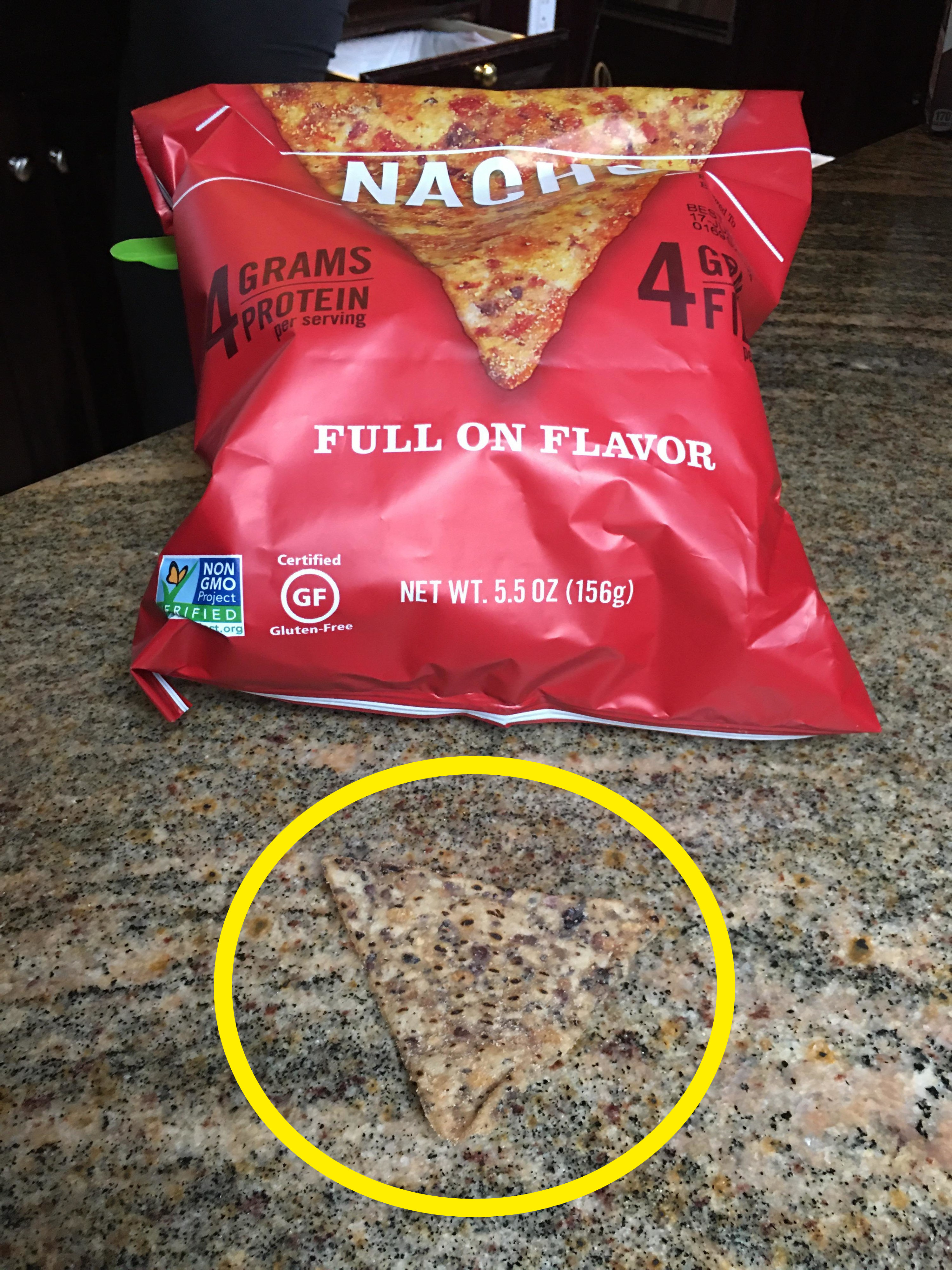 A nacho chip on a counter that blends in with the pattern of the granite counter