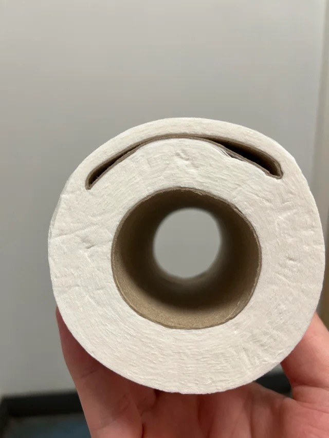 a roll of toilet paper with 2 cardboard tubes in the middle, one flattened