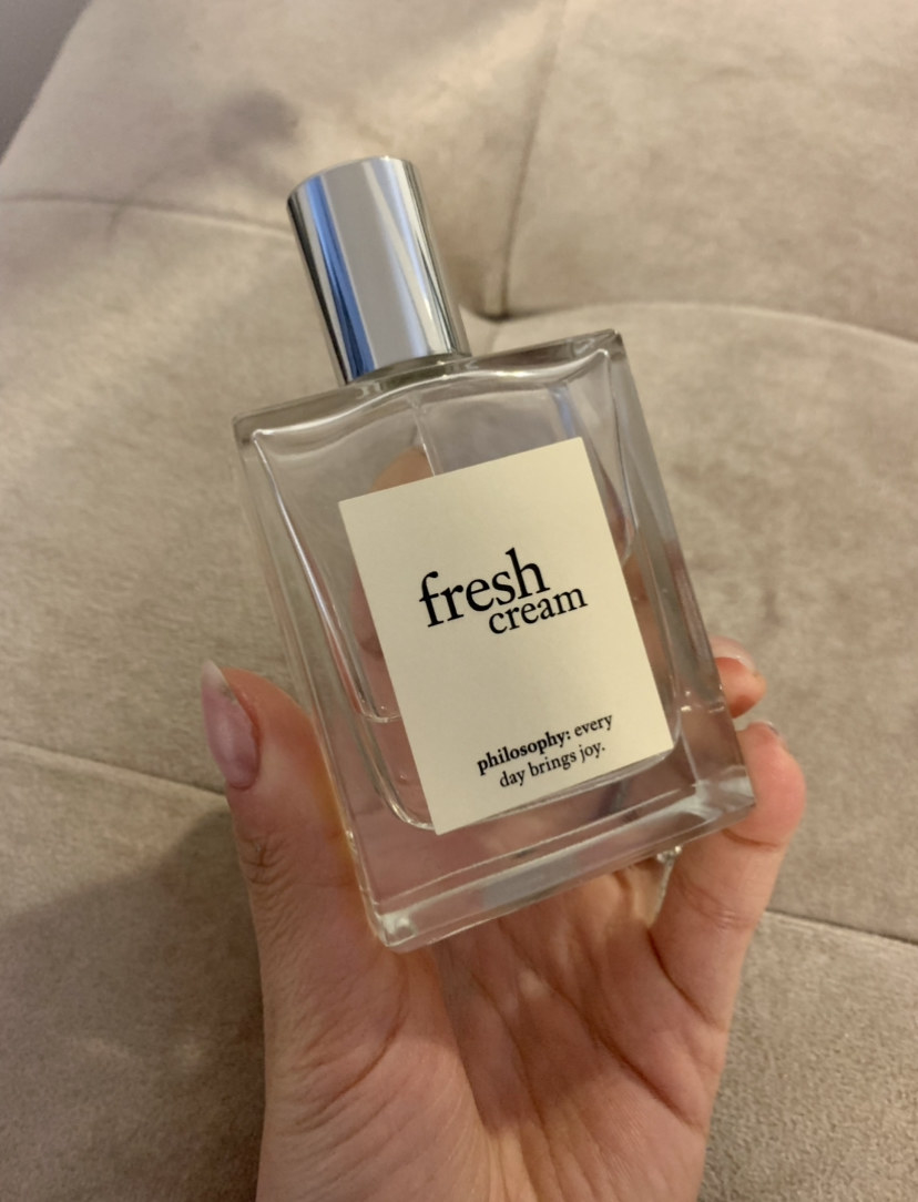 May holding the bottle of fragrance