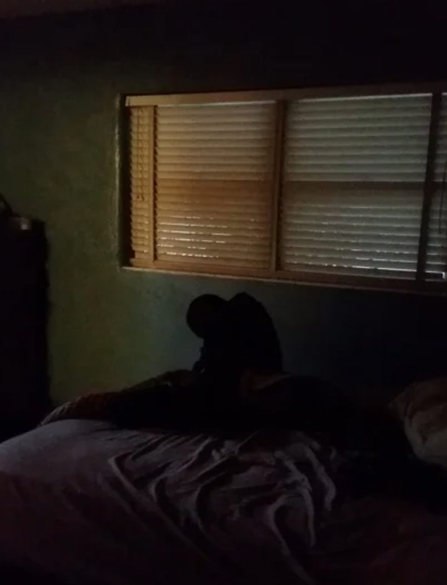 Silhouette of what looks like a person, but its just a bag on a bed