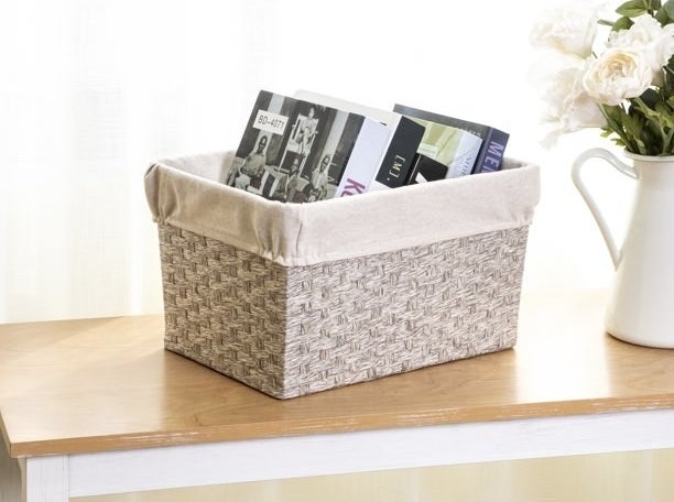 a gray paper rope storage basket holding books