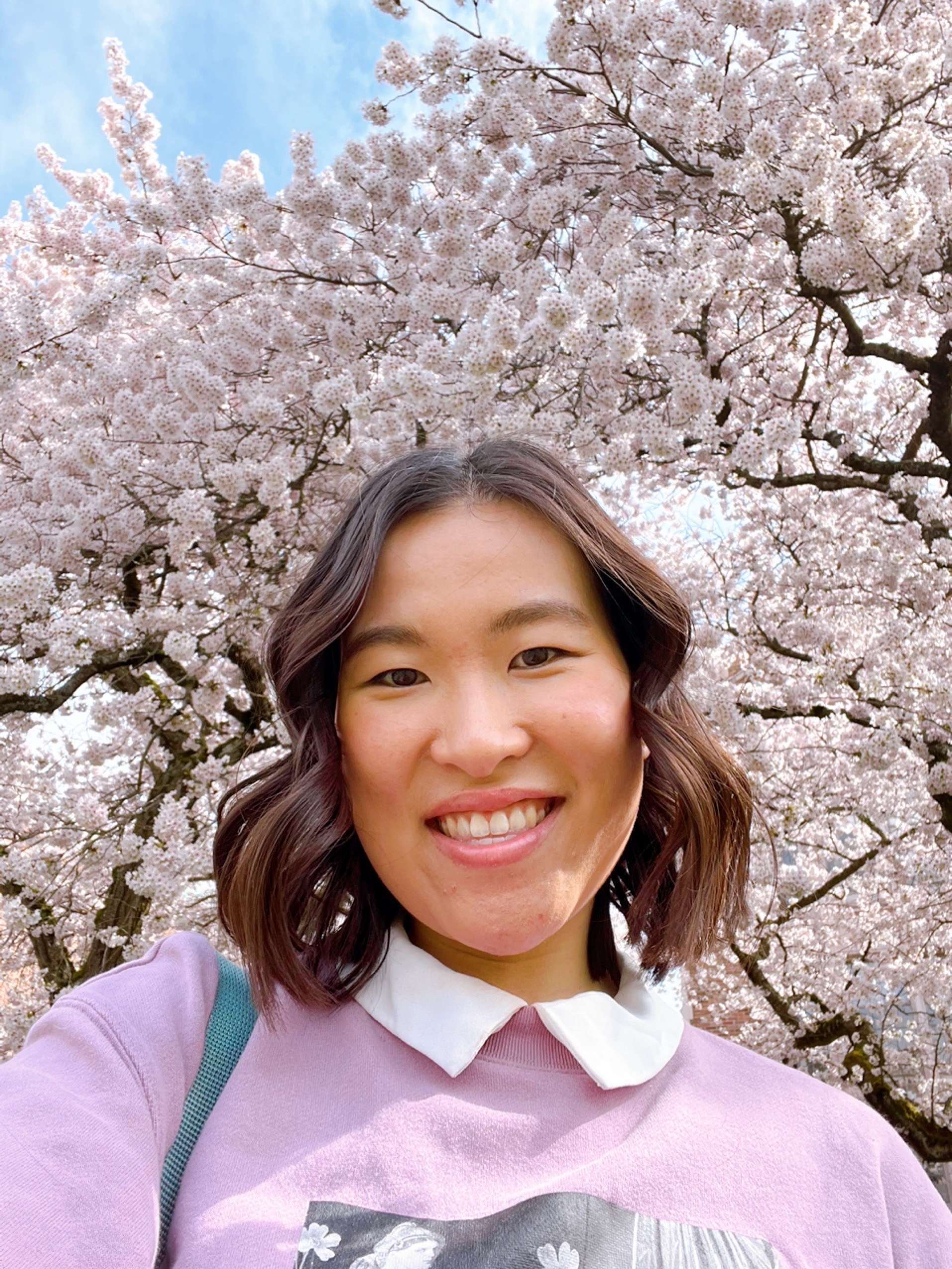 selfie of Michelle in front of cherry blossom trees