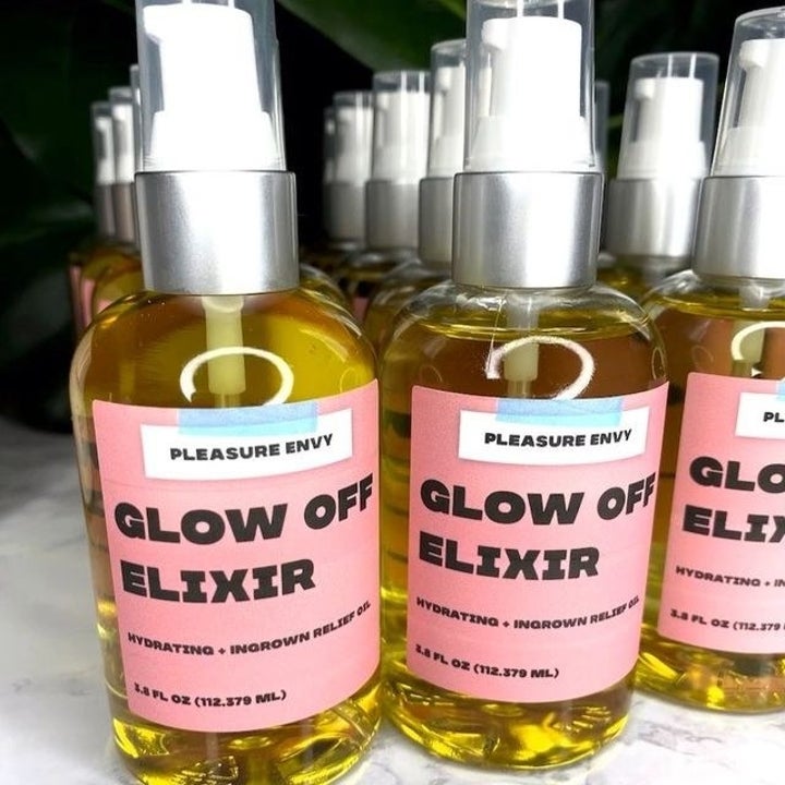 Bottles of body oil with pink label "glow off elixir"