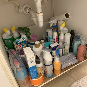 unorganized under sink cabinet