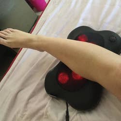 A reviewer resting their calf on the massager
