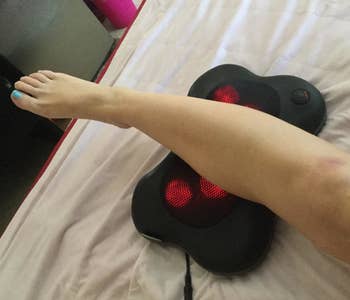 A reviewer resting their calf on the massager