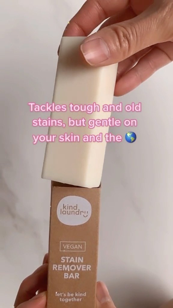 A person holding up the stain remover bar in its package