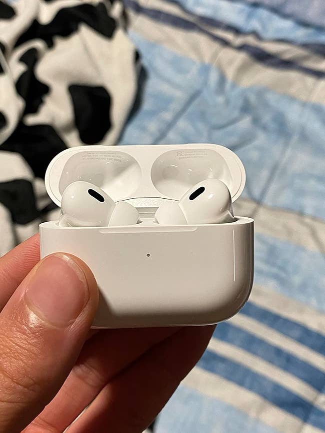 A reviewer holding the AirPod case with the headphones put away in their designated spot