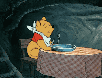 Pooh with bib dancing in seat at table
