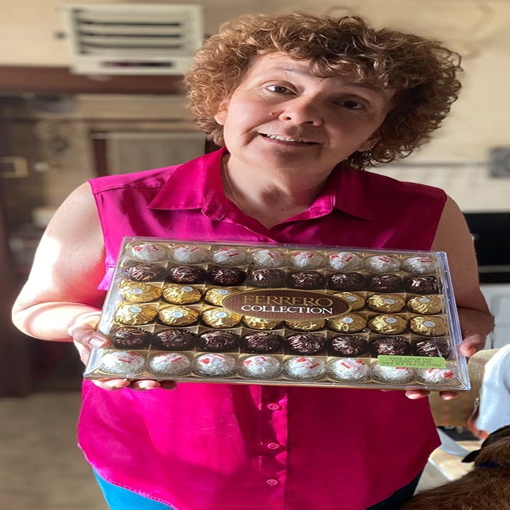 A reviewer holding the case of 48 chocolates in three varieties