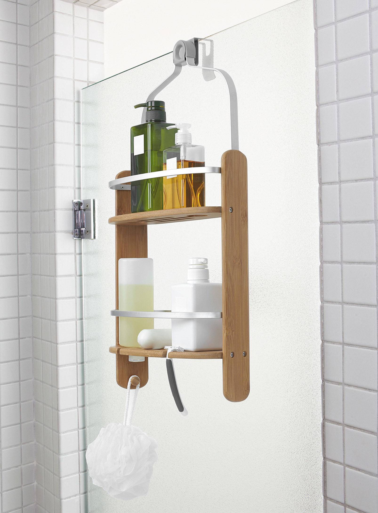 a bamboo shower caddy hung on a shower wall