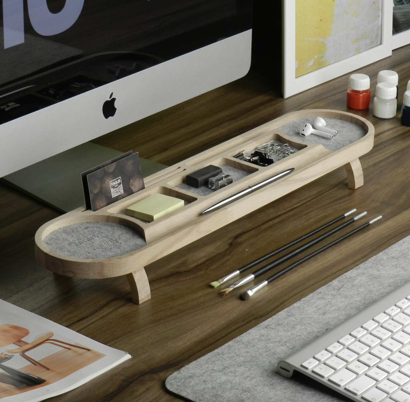 a minimalist wooden desktop organizer filled with office supplies