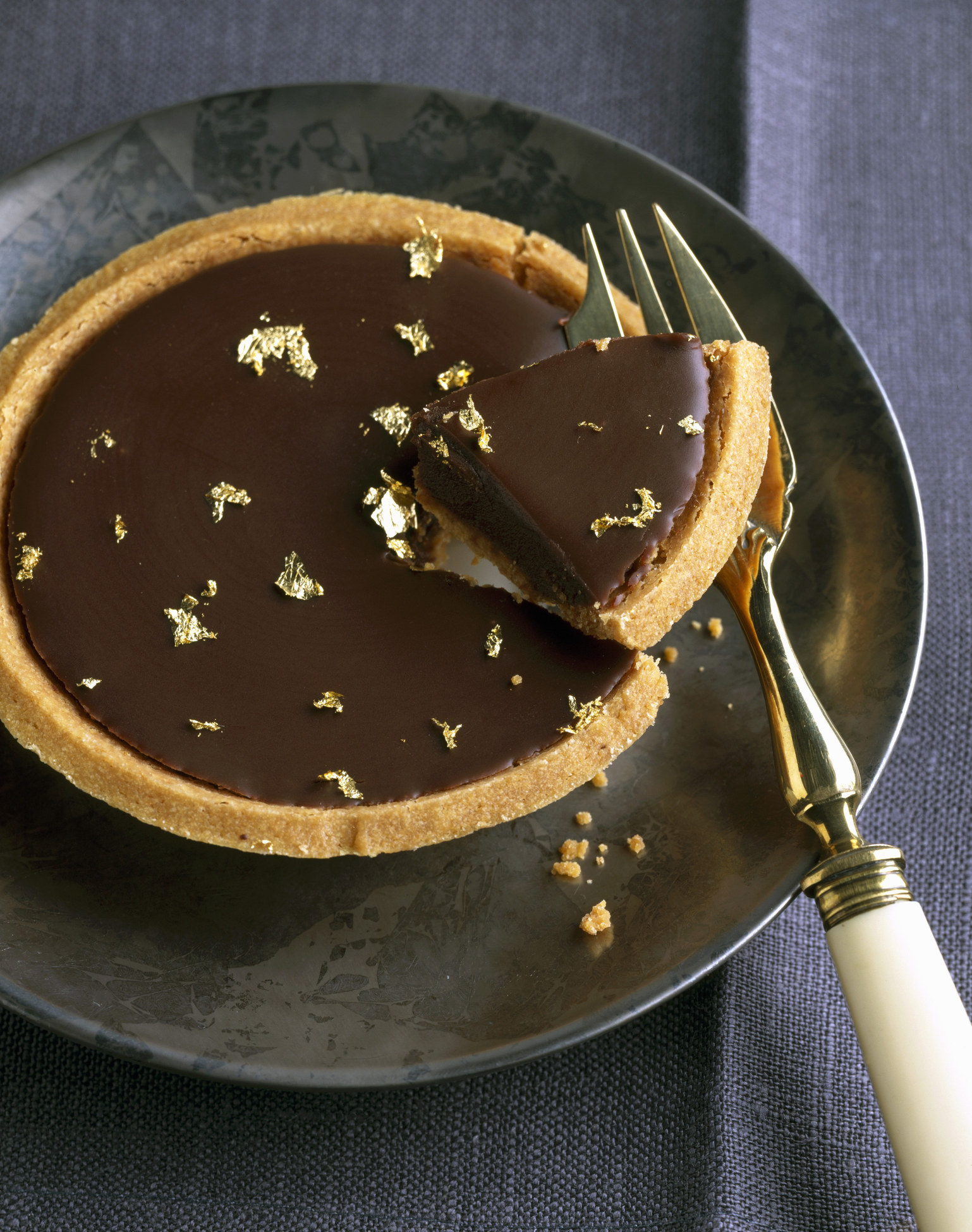 Dark chocolate tartlet with gold flakes.
