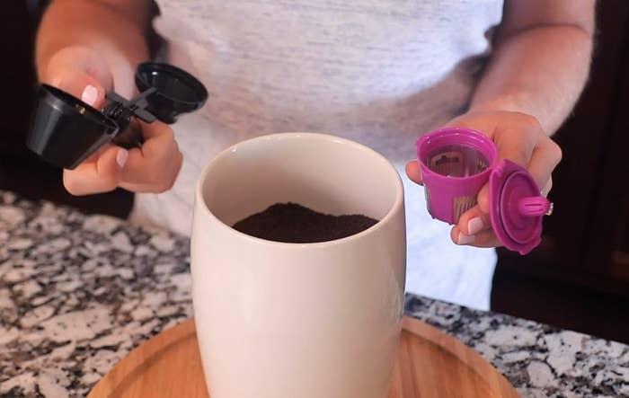 A person packing the coffee pod with ground coffee