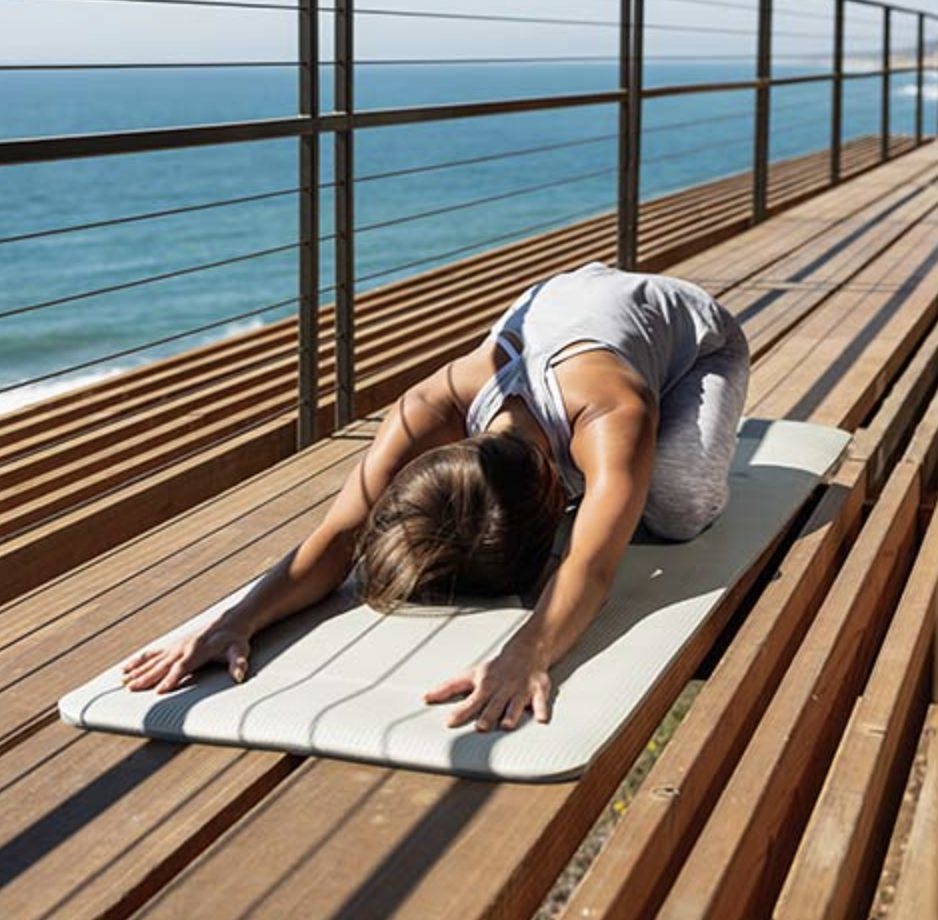 a person doing yoga on a deck outside on top of the thick mat