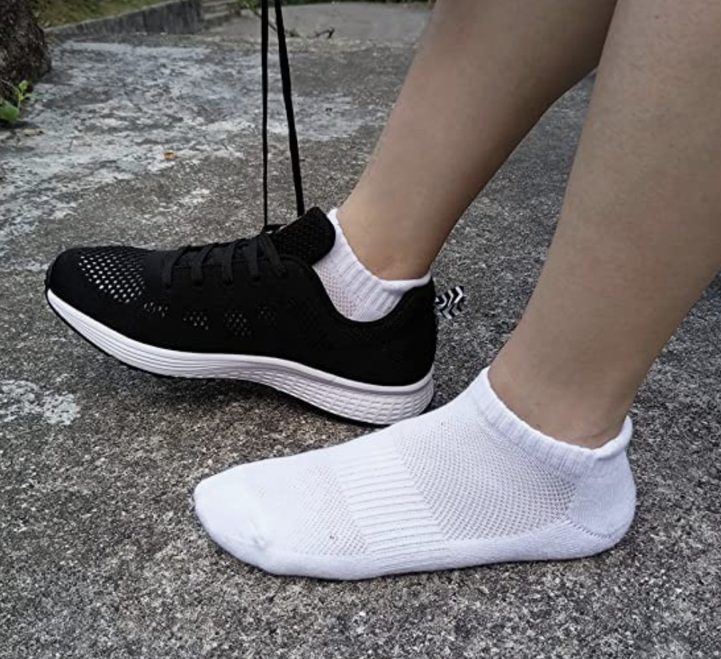 a person wearing the socks with a pair of running shoes outside