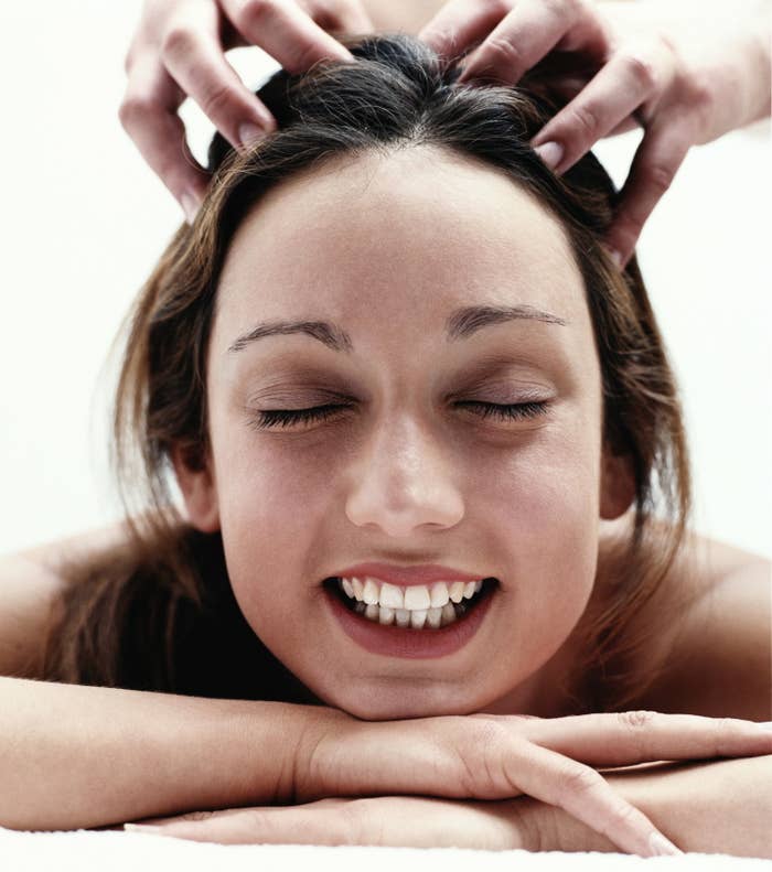 a woman getting her head scratched