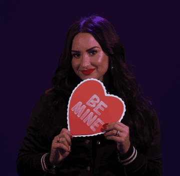 Demi Lovato holds up a paper heart that says &quot;Be Mine&quot;