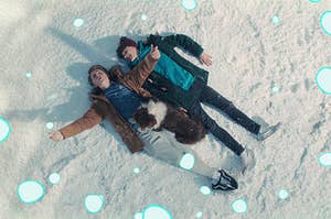 Two young lovers lay in snow with a dog, while cartoon snowflakes fall around them.