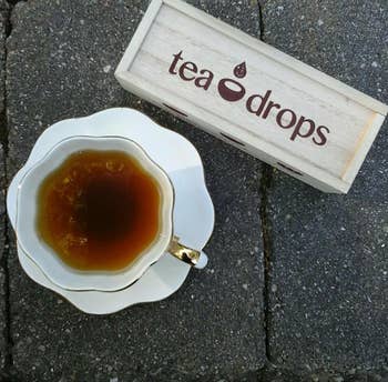 A reviewer's cup of tea next to the Tea Drops box