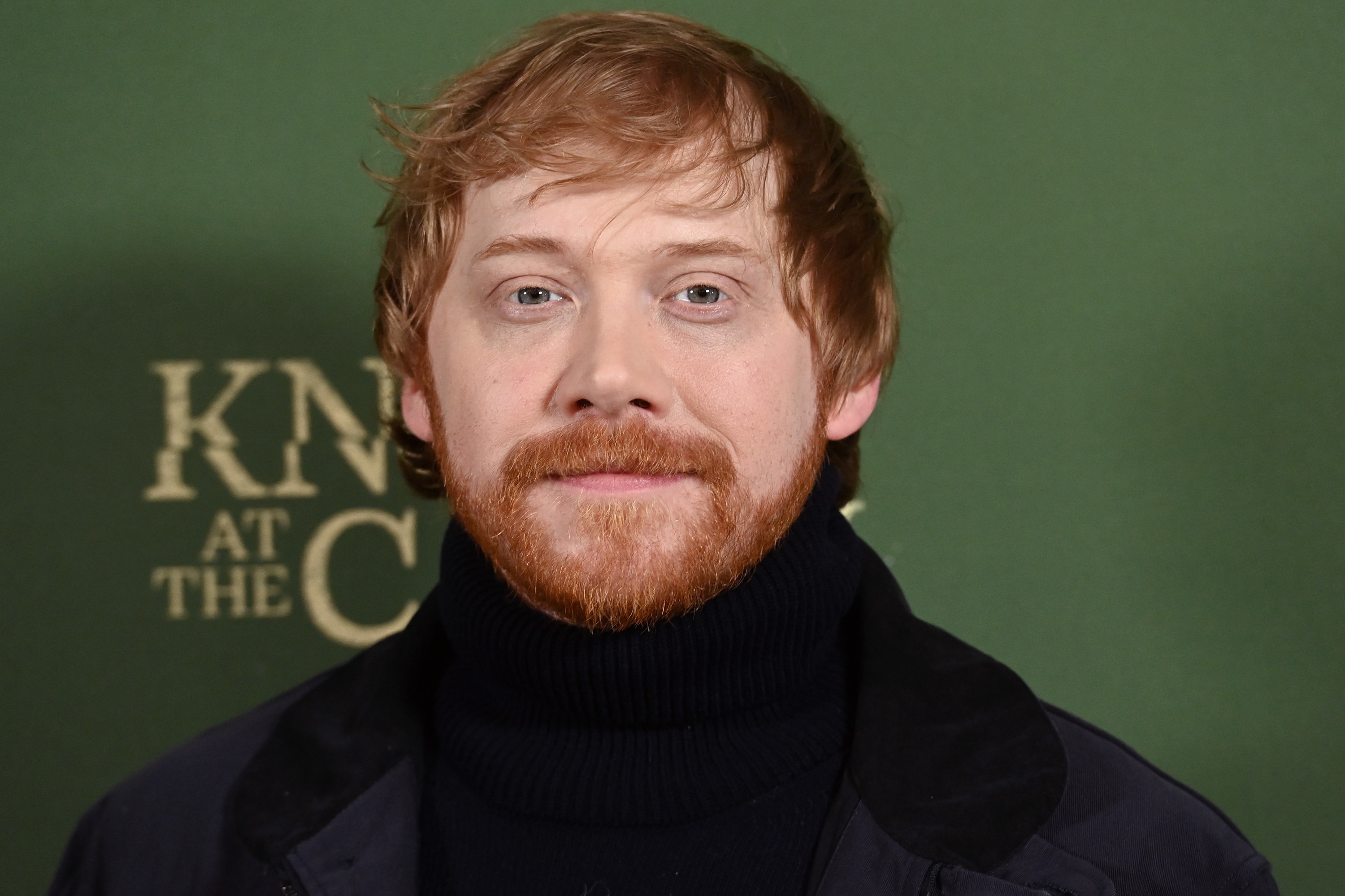 A closeup of Rupert smiling for the cameras at a red carpet event