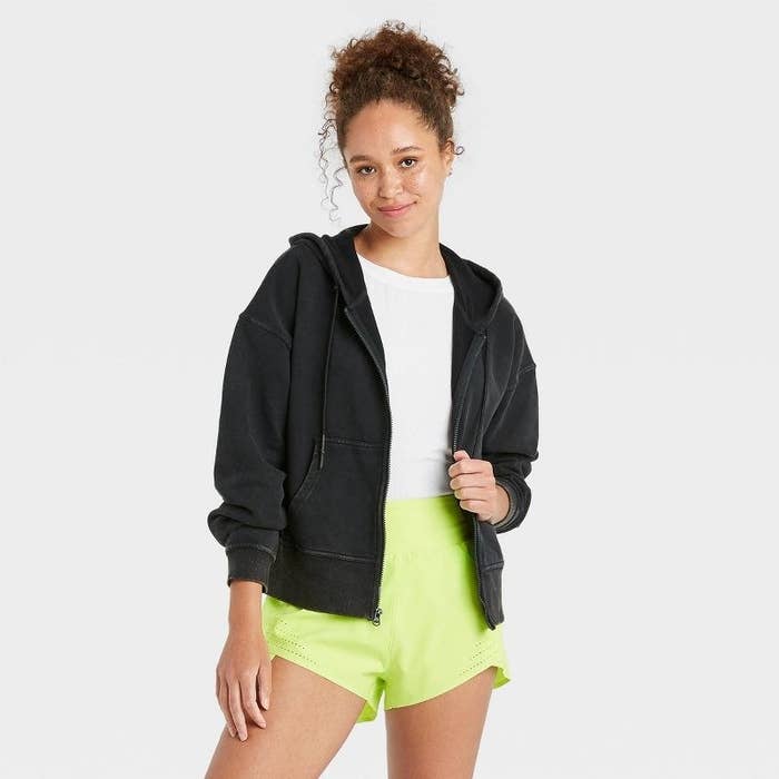 Model wearing black zip-up hoodie
