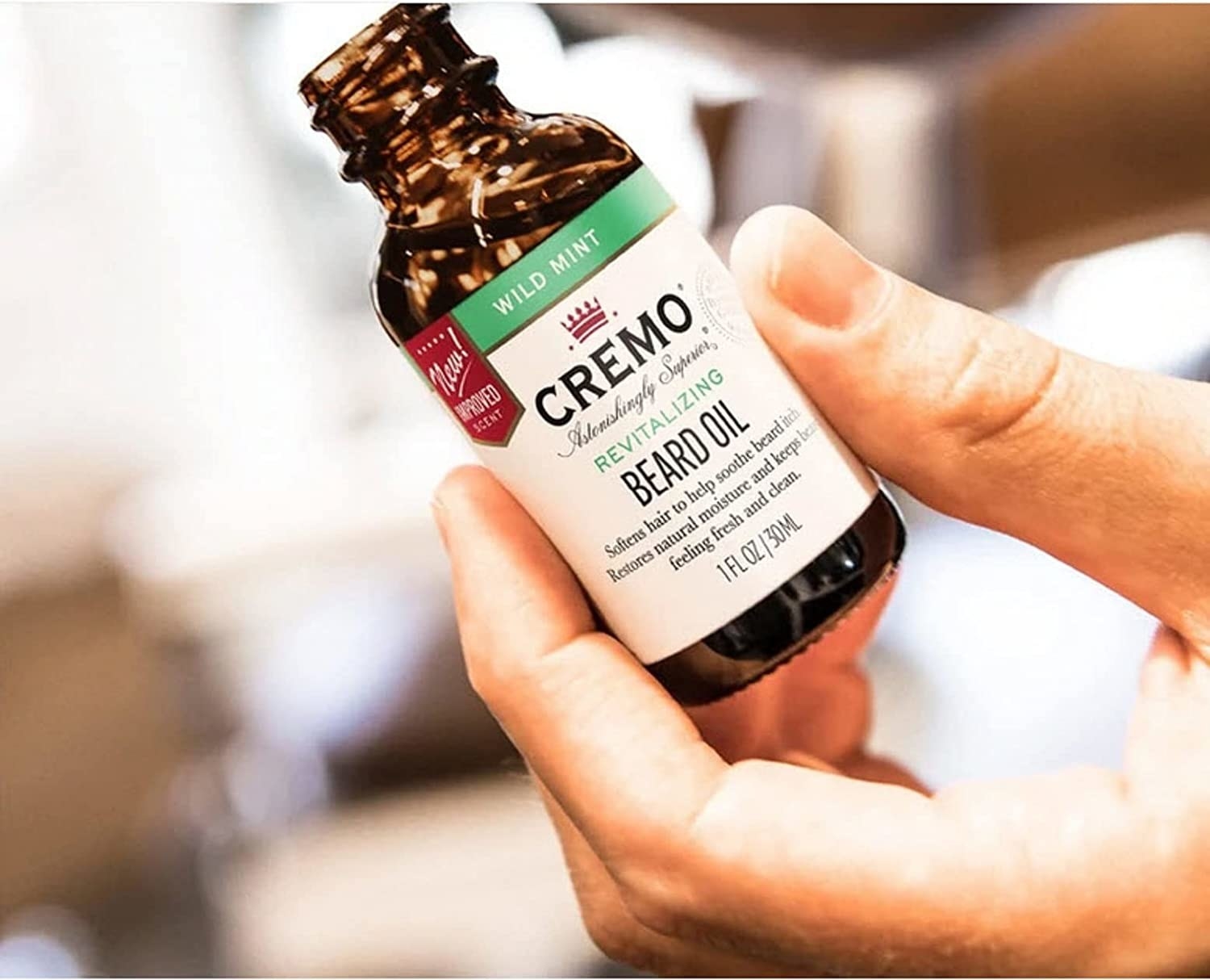 A model holding a bottle of the mint scented beard oil