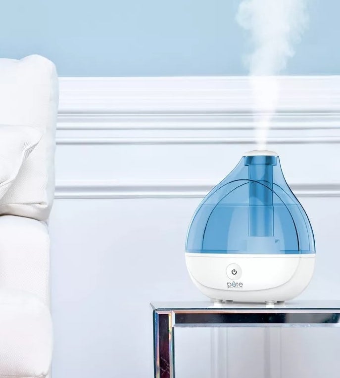 Blue and white plastic humidifier emitting vapor