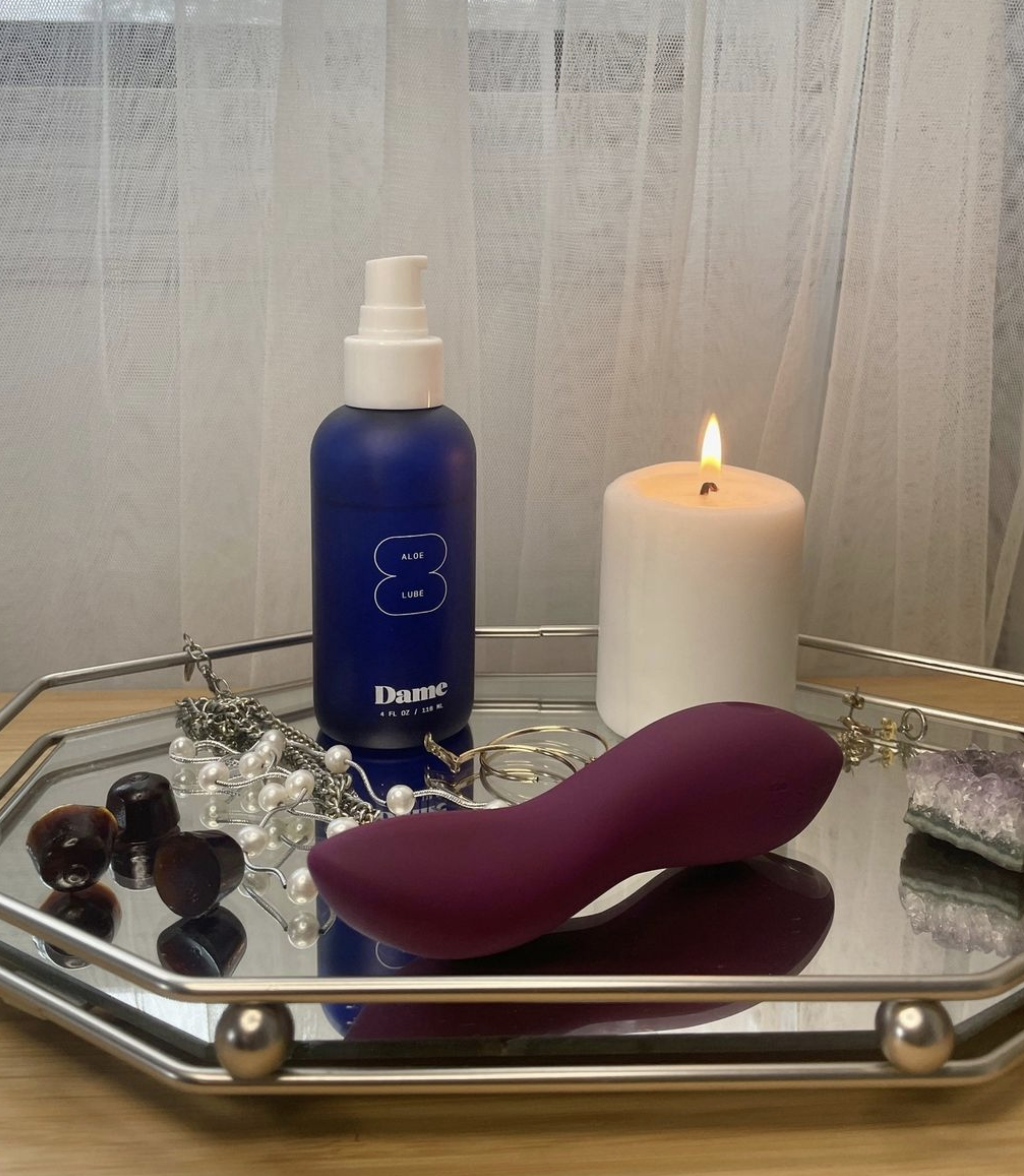 the lube bottle next to a vibrator and candle