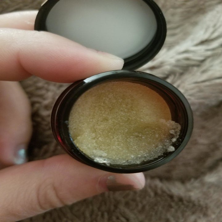 Reviewer holding container of lip scrub