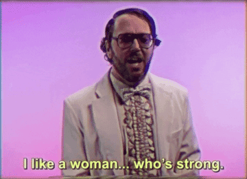 man with glasses a beard and a receding hairline dressed in a ruffled dress shirt saying i like a woman who is strong