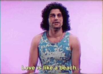 a man with a curly mullet in a tight tank top saying love is like a beach dont get the sand inside of you