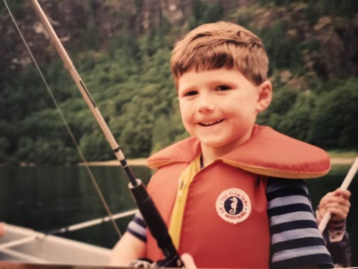 Thomas as a child in a life jacket and holding a fishing rod