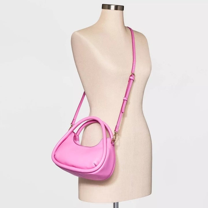 the purse worn as a crossbody bag in pink