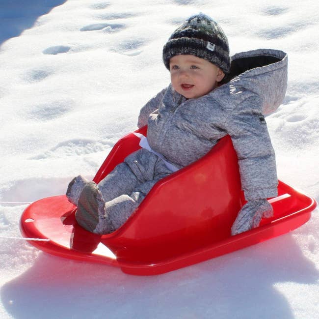 A baby model on a red sled
