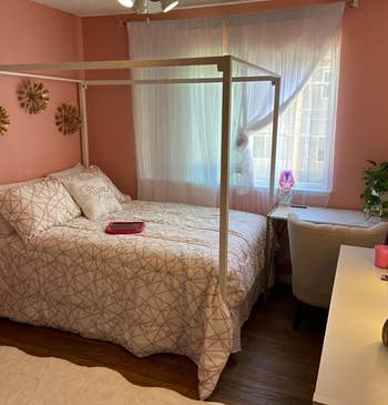 Reviewer's white canopy bed is shown