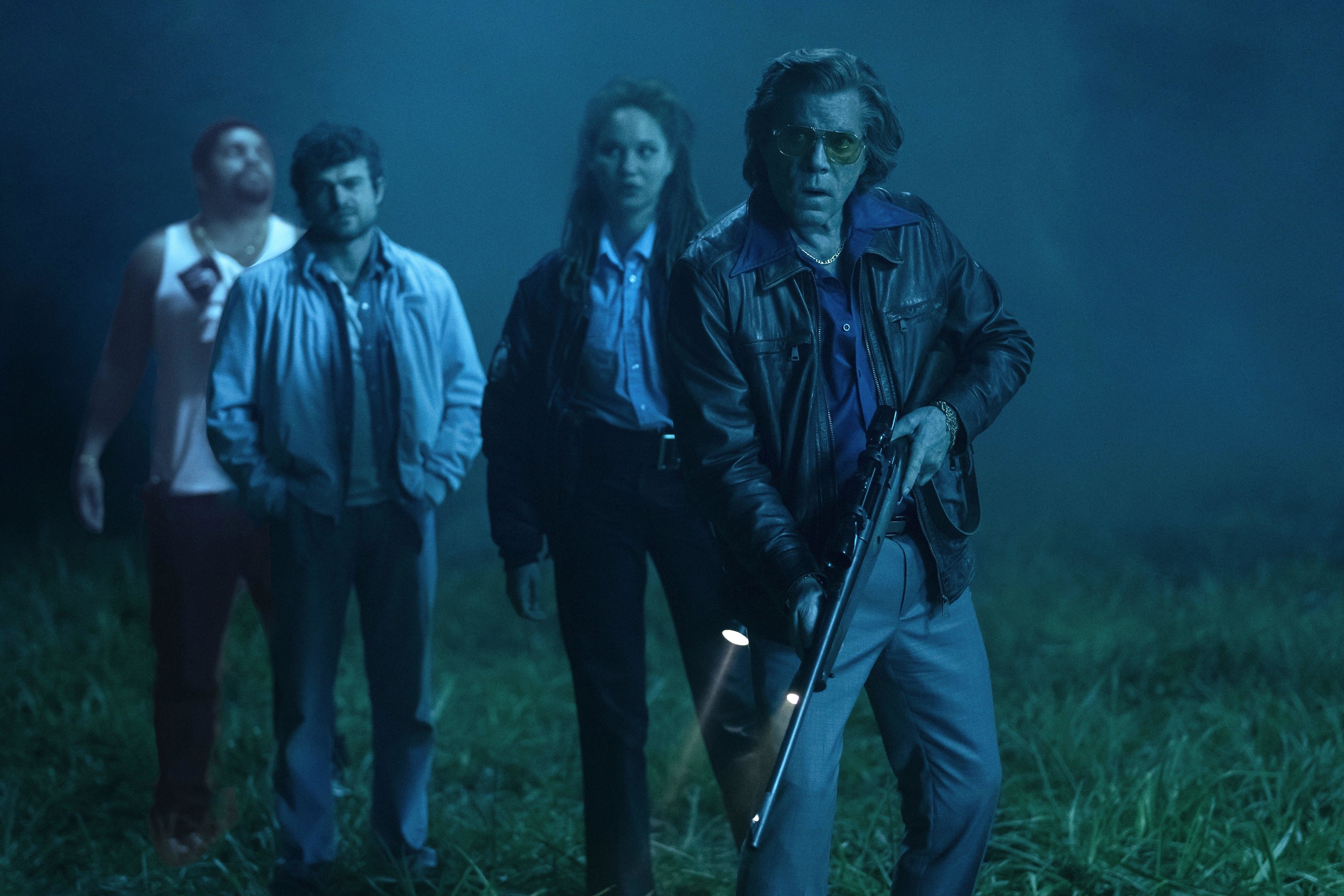 Four strangers hunt for something in a misty field at night