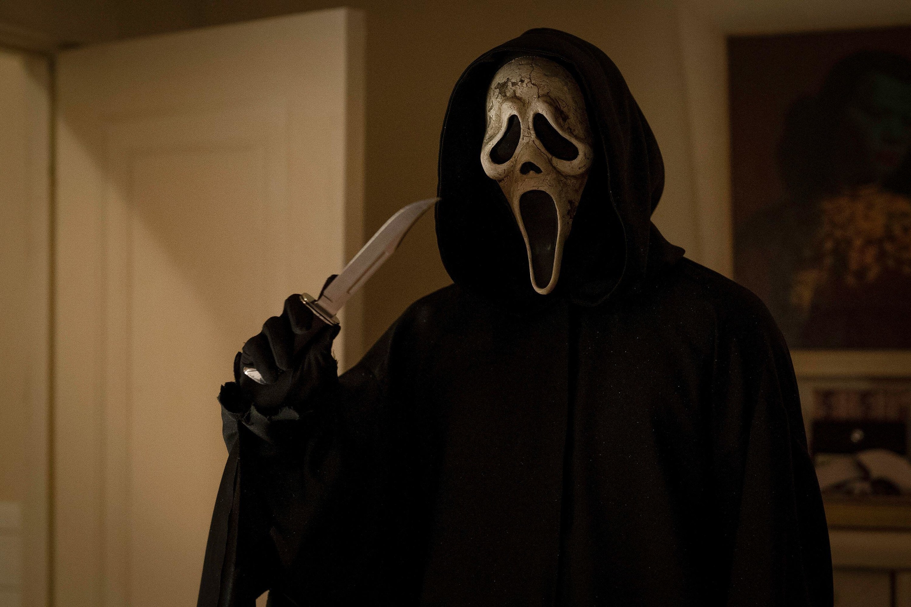 A ghostface killer in a weathered mask holds a large knife