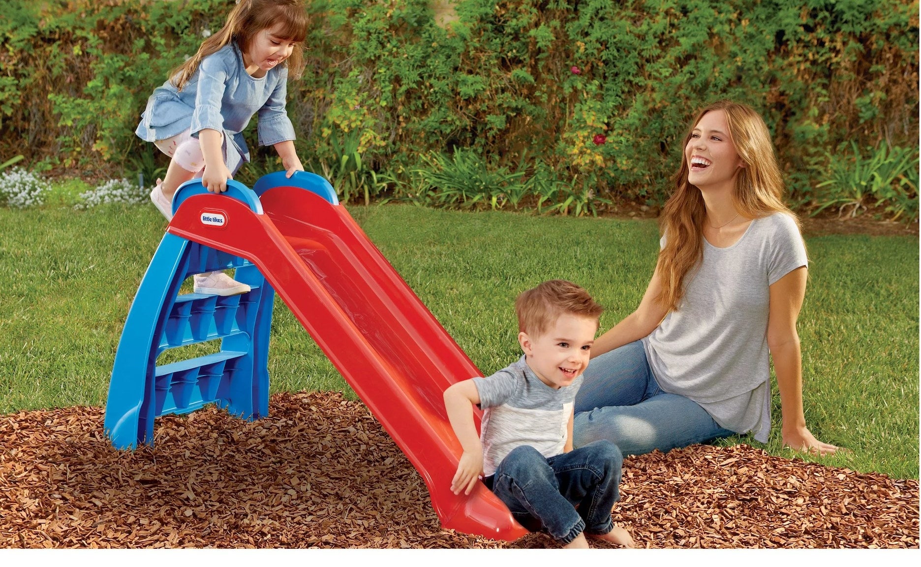 Two kids plays in slide with parent