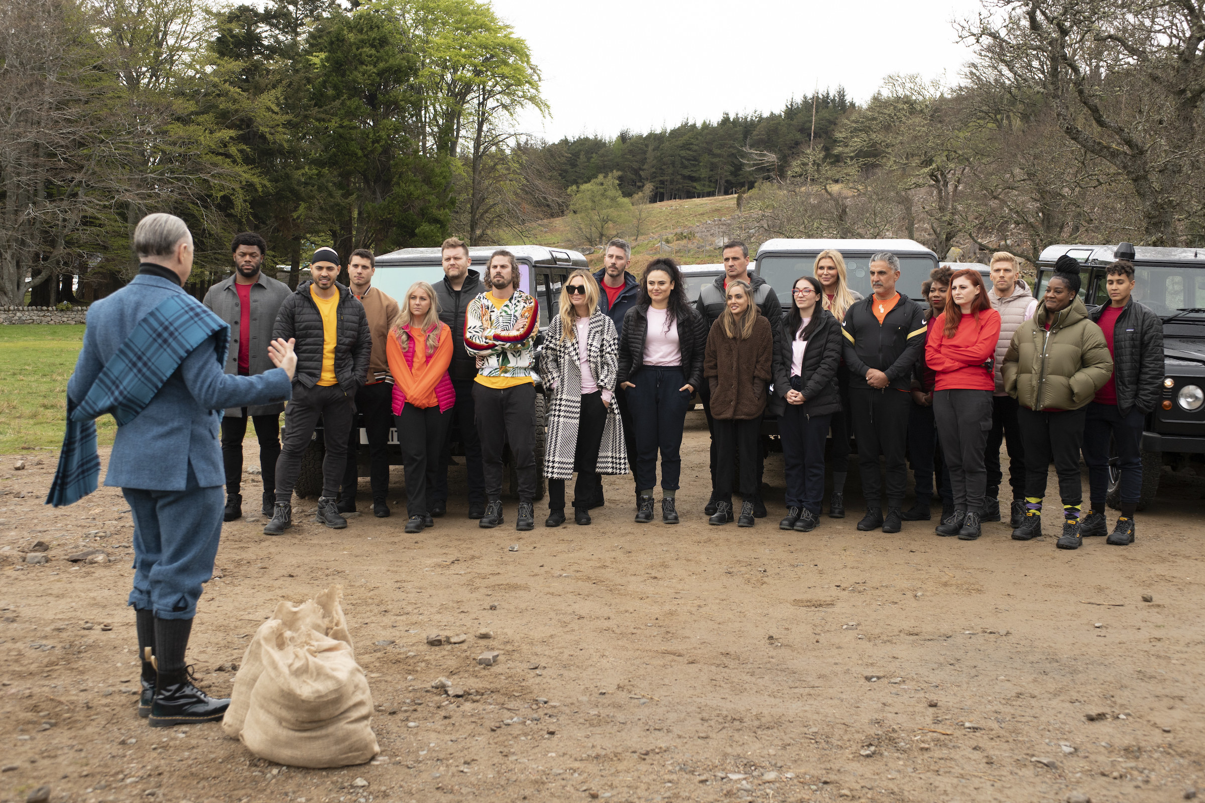 The cast of he Traitors stand in a field