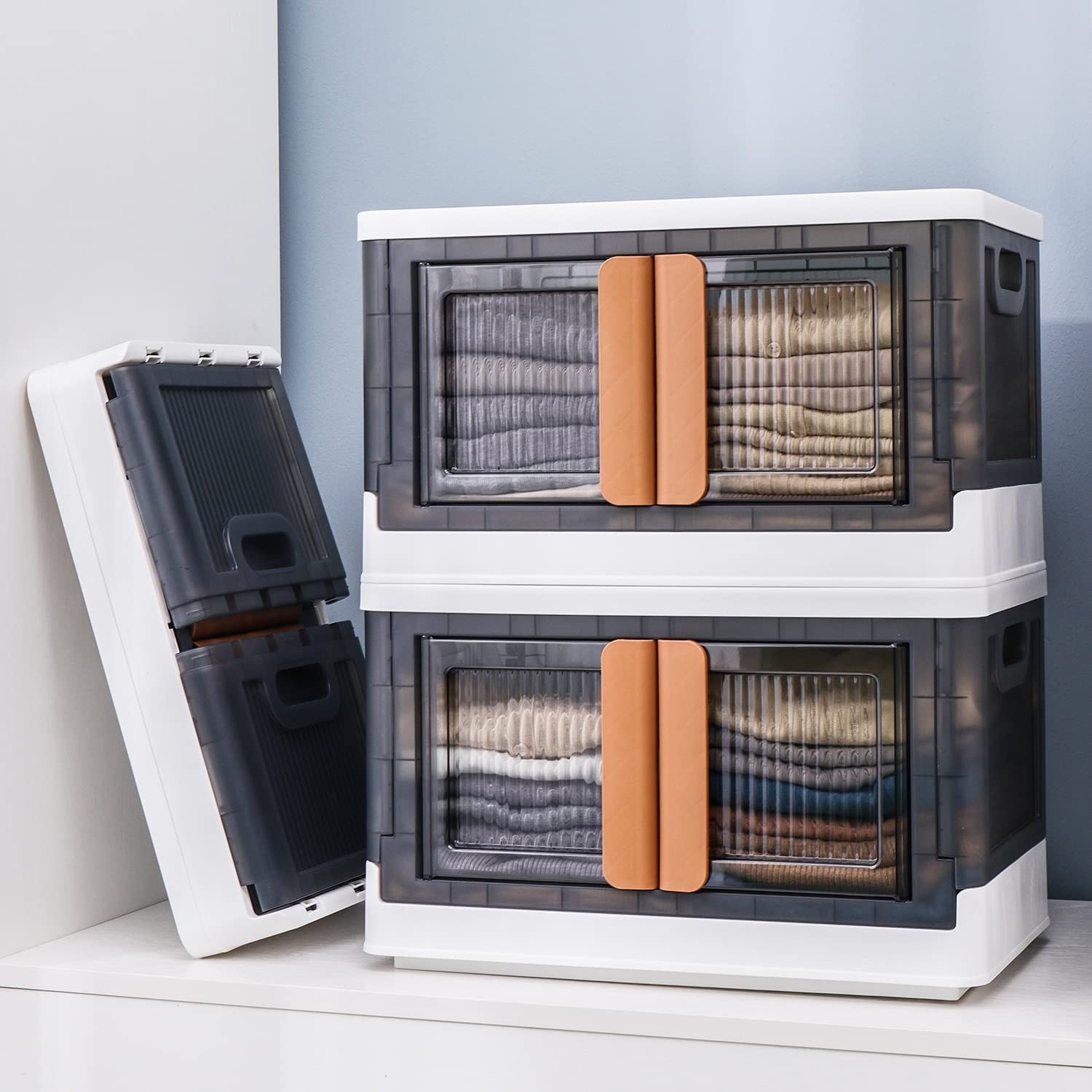 a pair of stackable plastic bins with front-facing doors in a closet