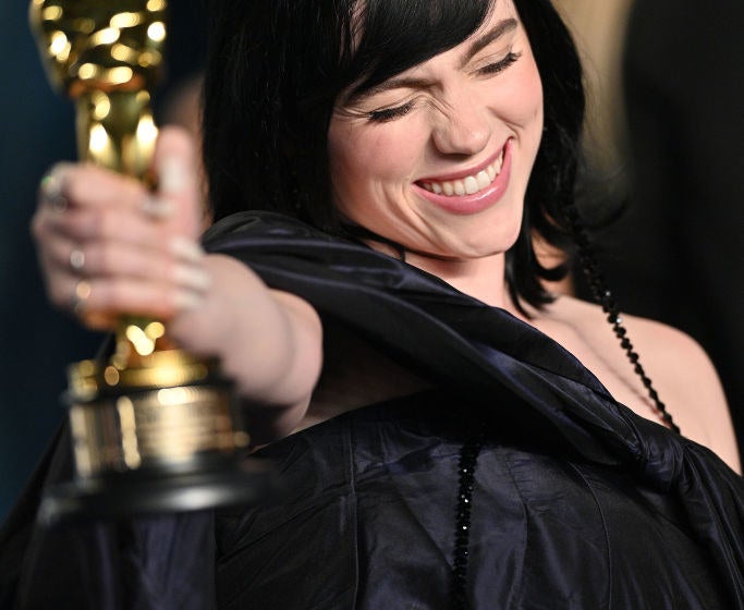 Billie smiles with her eyes shut as she holds her Oscar