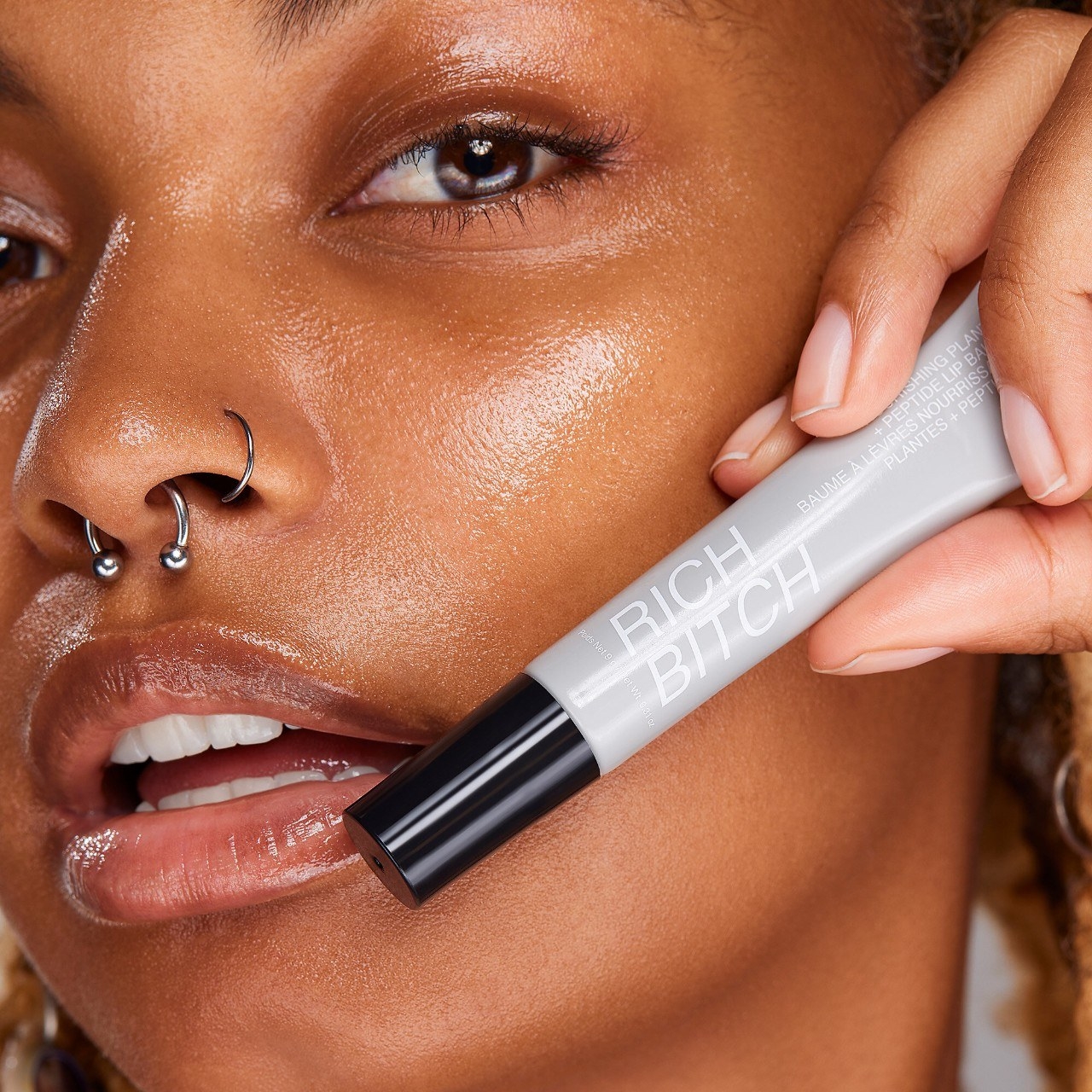 a person holding the lip balm against their face