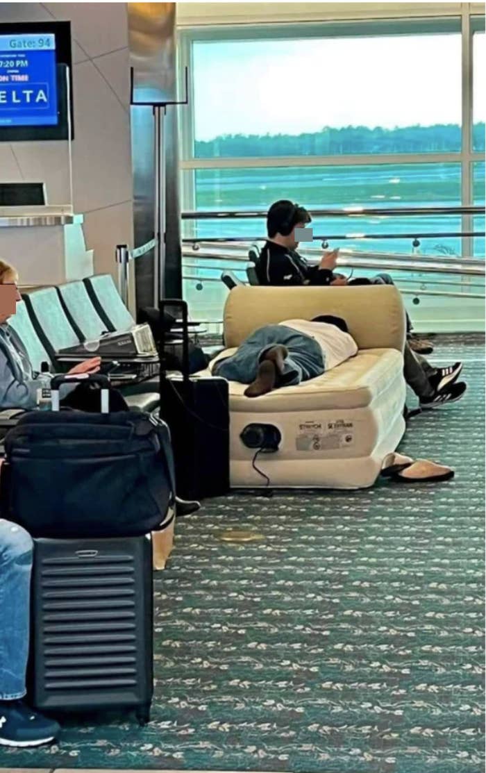 Someone sleeping on a blow-up mattress at the airport