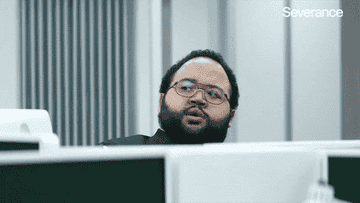 Man peeking over a cubicle wall