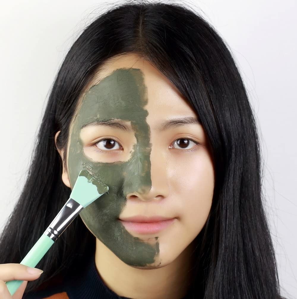 someone using one of the tools to apply a mask on their face